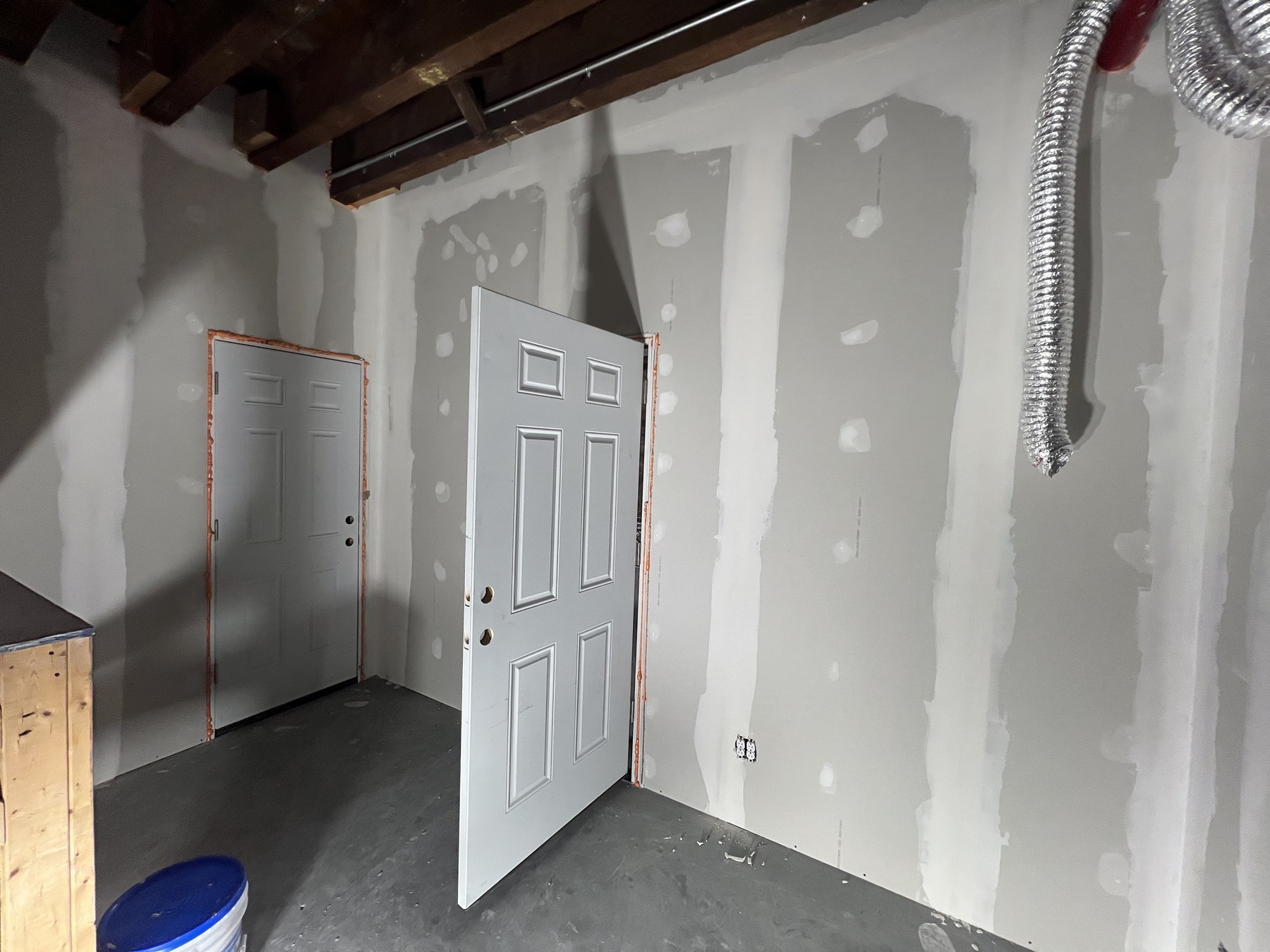 Drywall installation and joint finishing in progress in a residential room