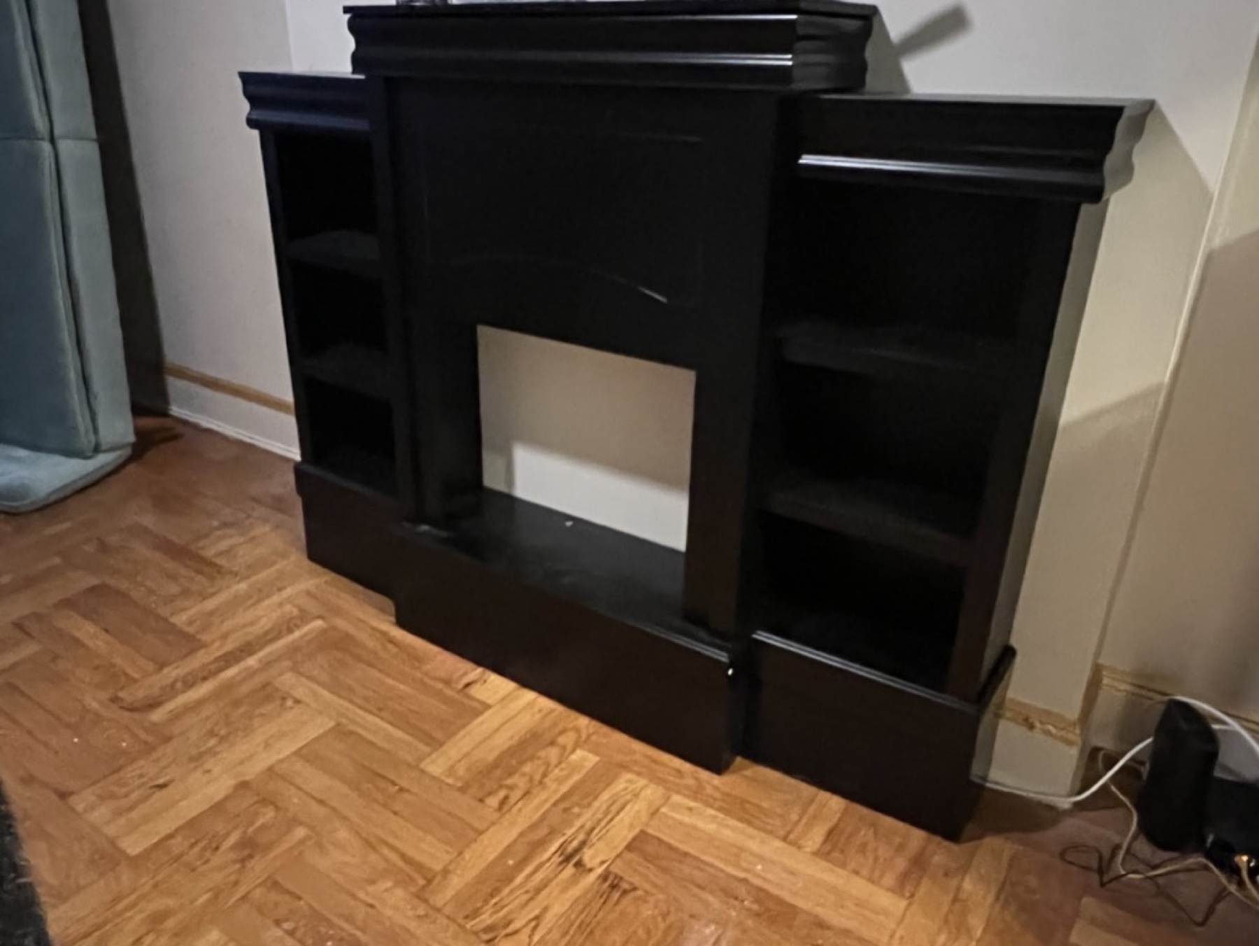 Completed black fireplace cabinet with a matching custom lower riser