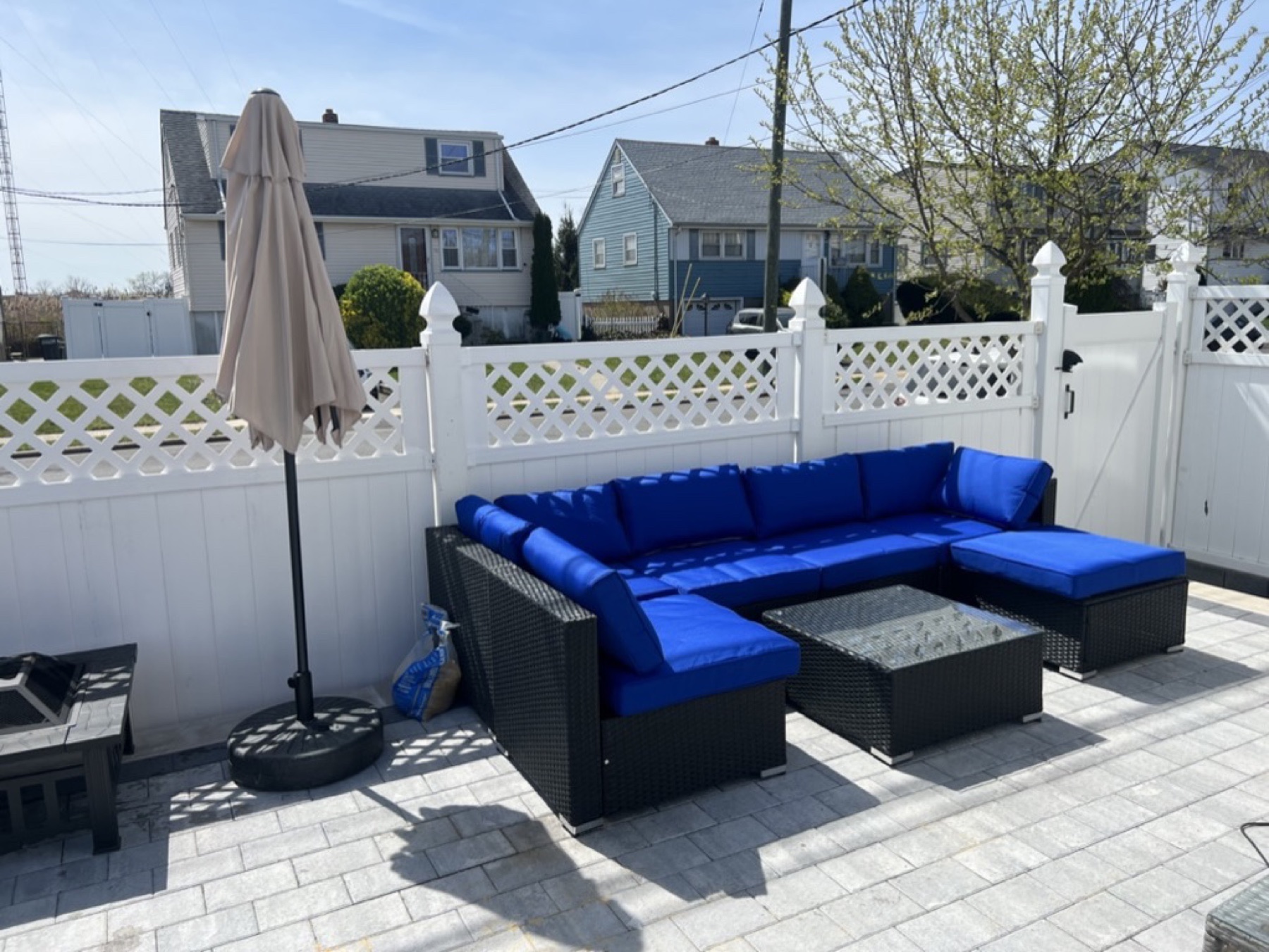 Completed black patio sectional with blue cushions, coffee table, and shade umbrella