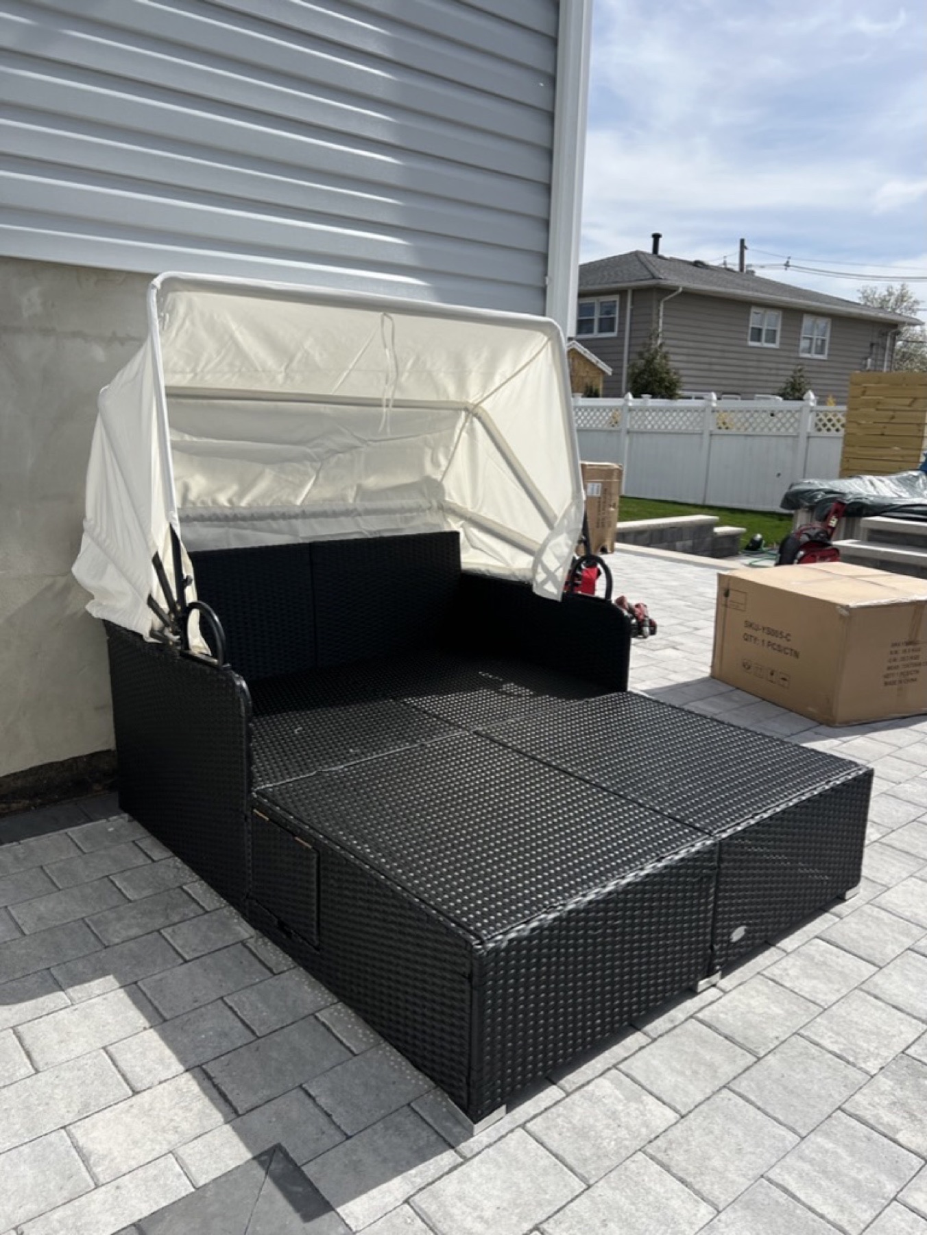 Canopy daybed assembled on a patio before cushions are installed