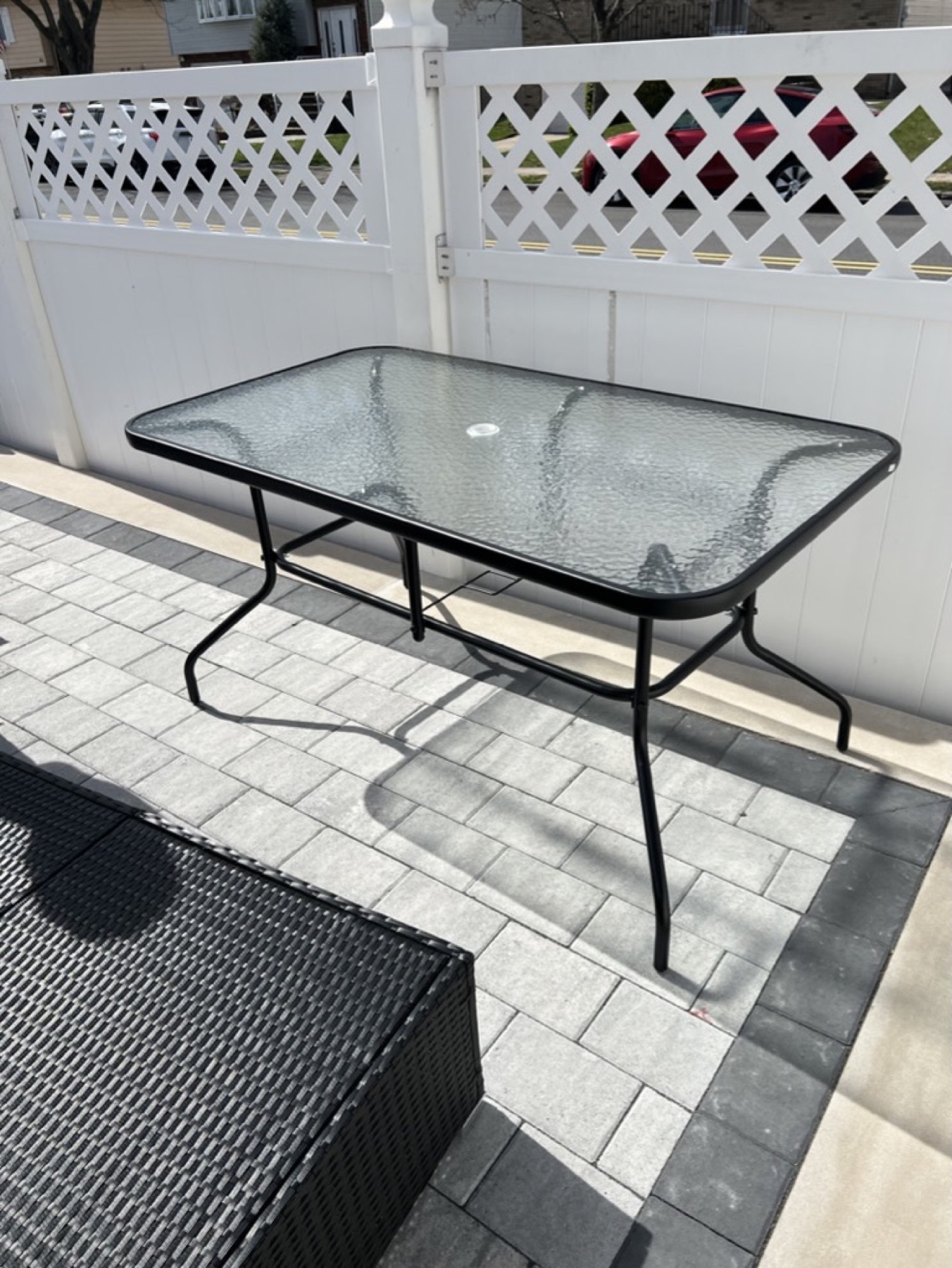 Assembled glass-top patio table beside outdoor seating
