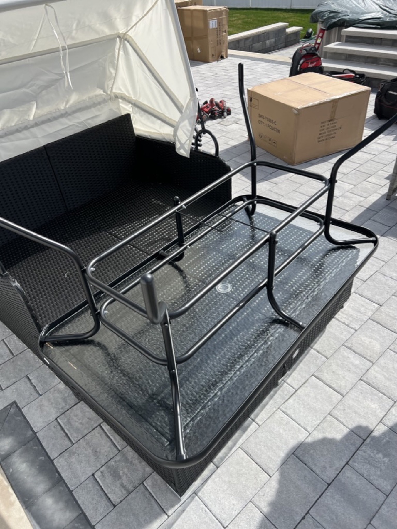 Outdoor table components positioned on the assembled canopy daybed